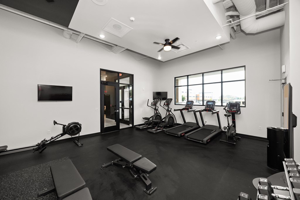 A gym with a variety of equipment including treadmills, exercise bikes, and weightlifting machines.