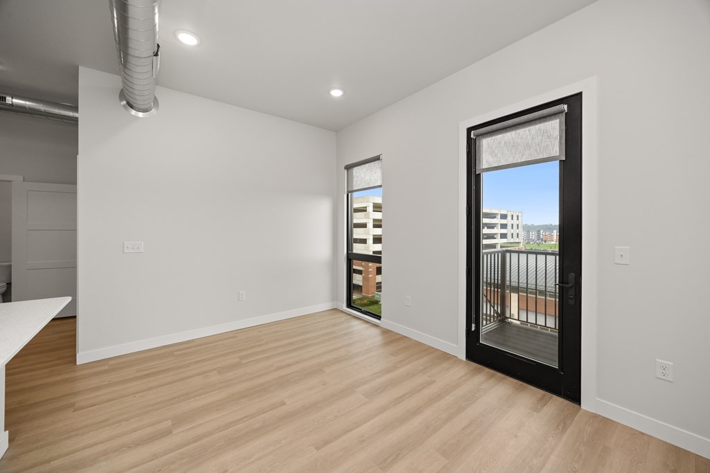 A room with a sliding glass door leading to a balcony.