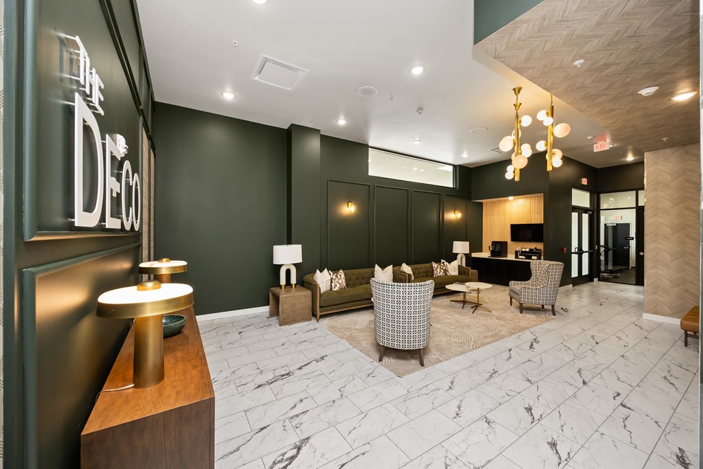 A reception area with a black sofa and a gold table.