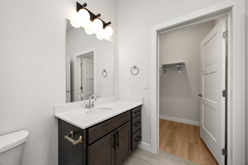A bathroom with a sink, mirror, and a white door.