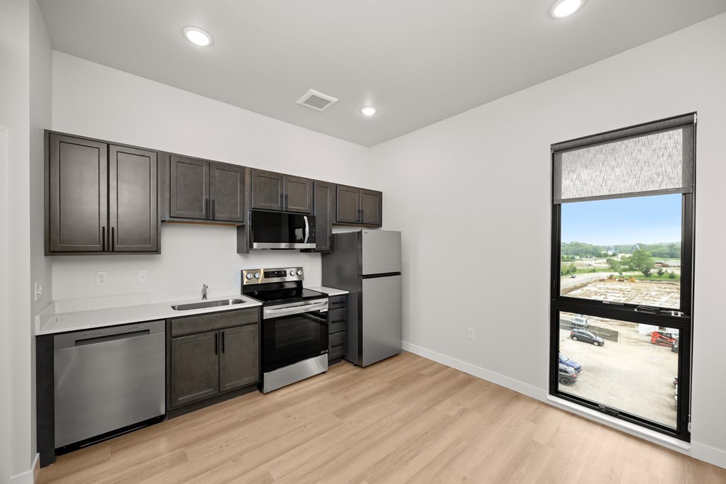 A kitchen with dark brown cabinets and stainless steel appliances.