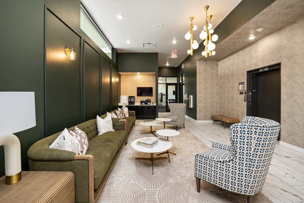 A living room with a green couch and patterned chair.