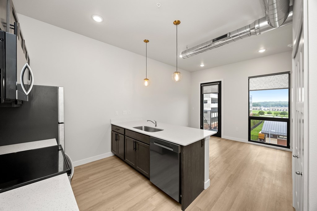 A modern kitchen with a large island and a view of the outdoors.