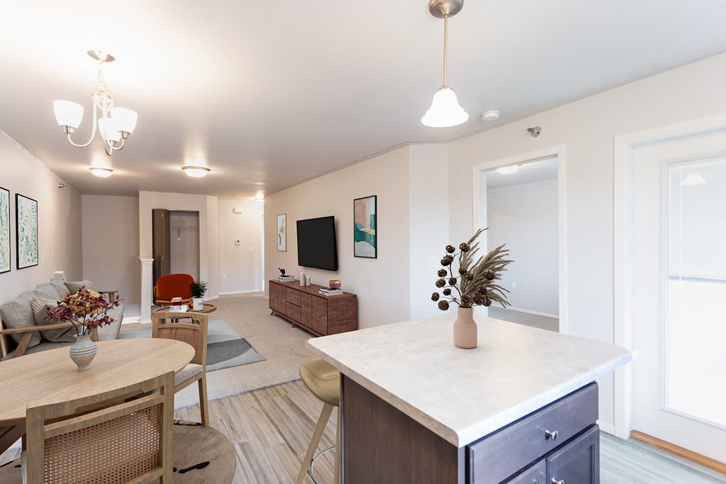 a living room and dining room with a white counter top and a kitchen