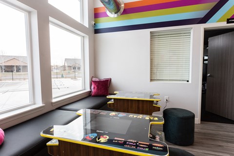 a seating area with a table and chairs and a large window