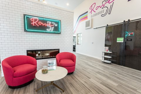 a living room with two red chairs and a coffee table
