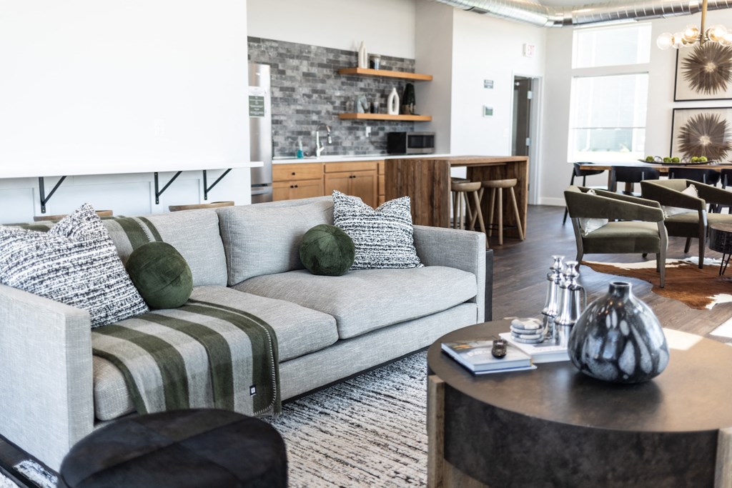 a living room with a gray couch and a table with pillows