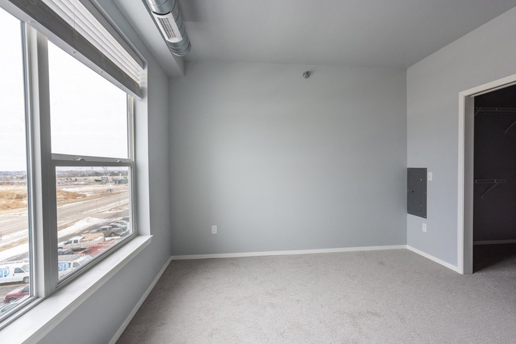 an empty room with a large window and white walls