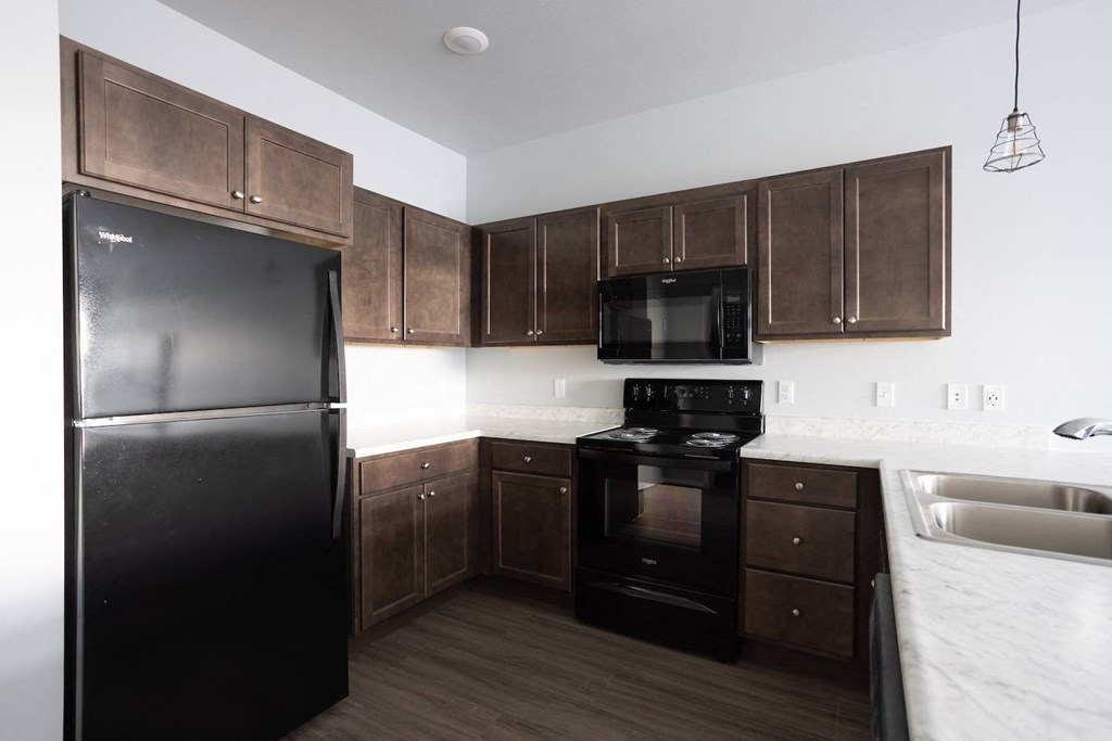 a kitchen with black appliances and wooden cabinets