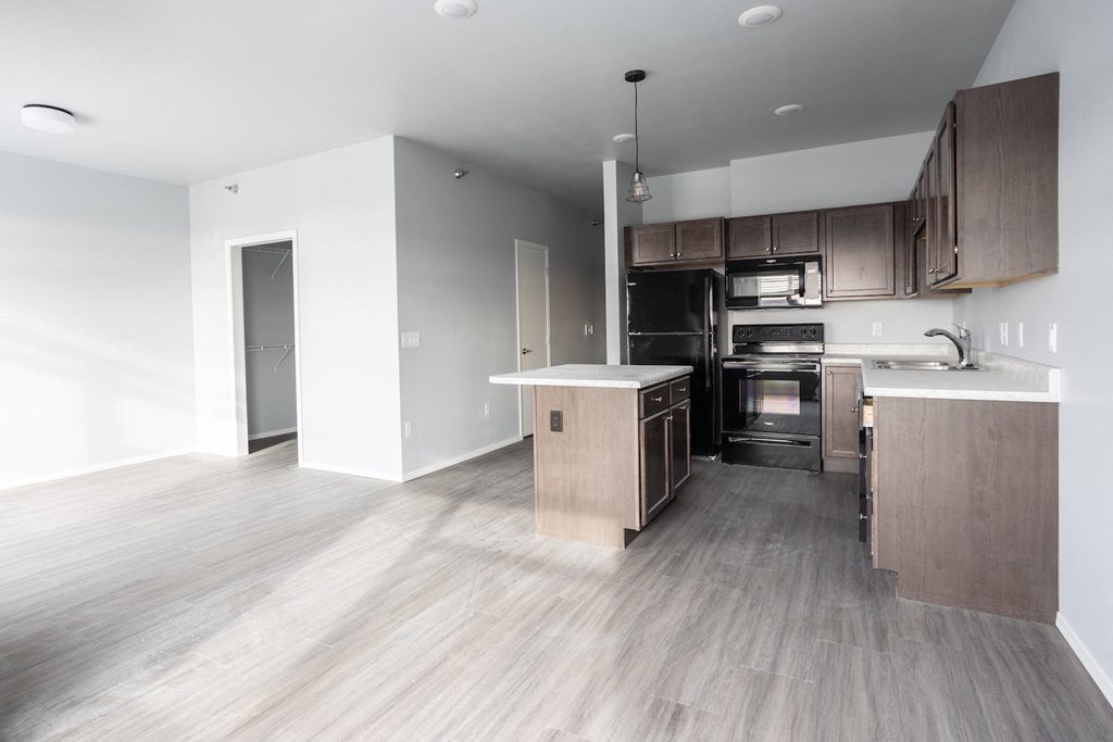 an empty kitchen with wooden floors and wooden cabinets