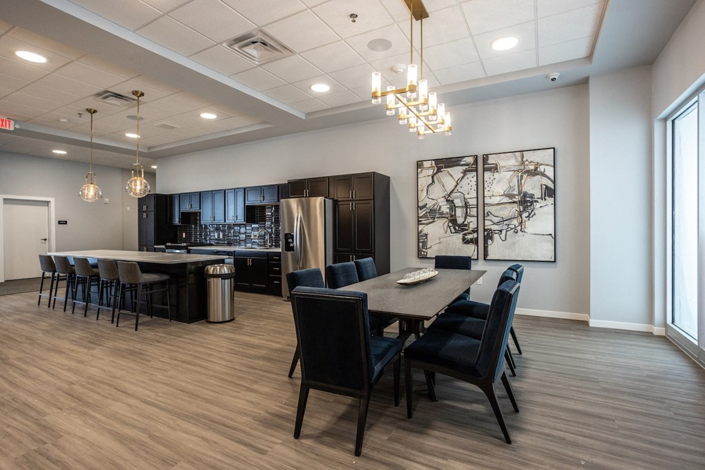 a dining room and kitchen area with a table and chairs and a kitchen