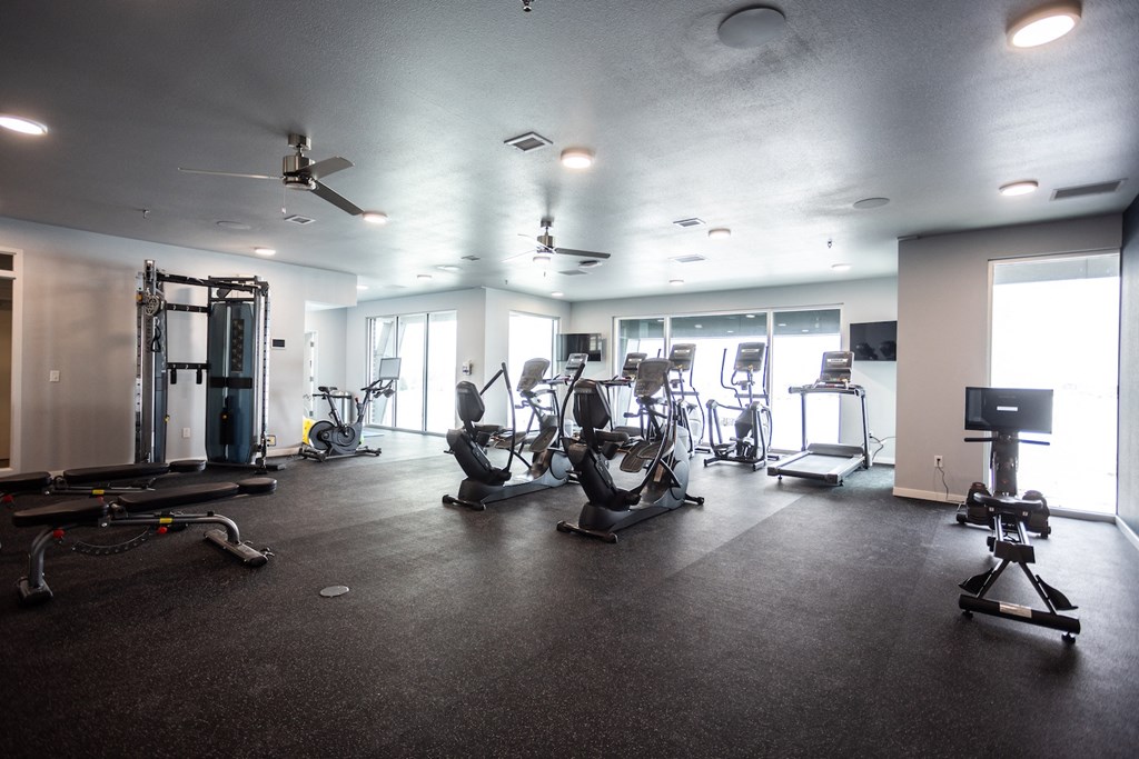 a large fitness room with various exercise equipment