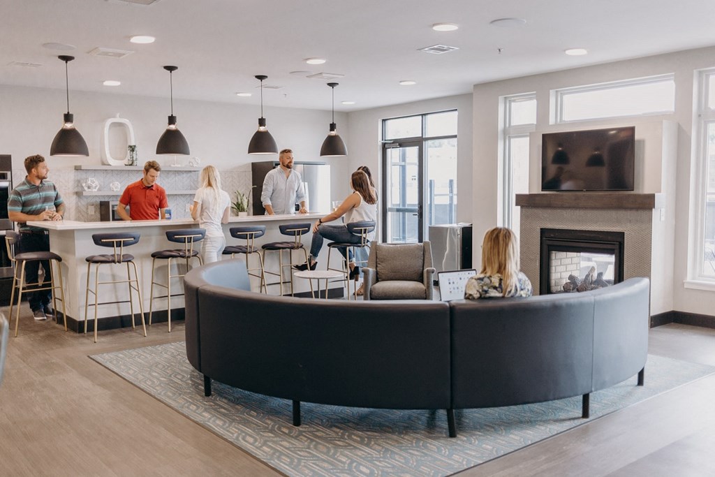 a group of people sitting around a living room with a fireplace