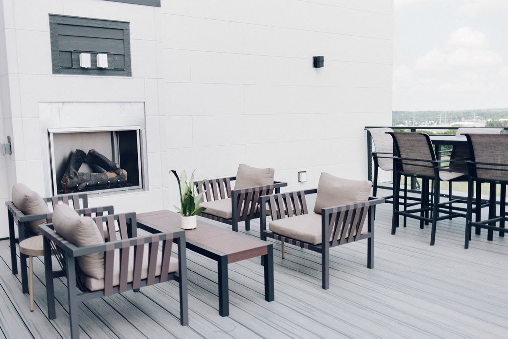 a patio with tables and chairs and a fireplace