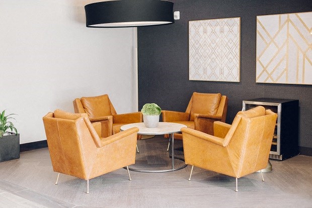a living room with orange chairs and a table