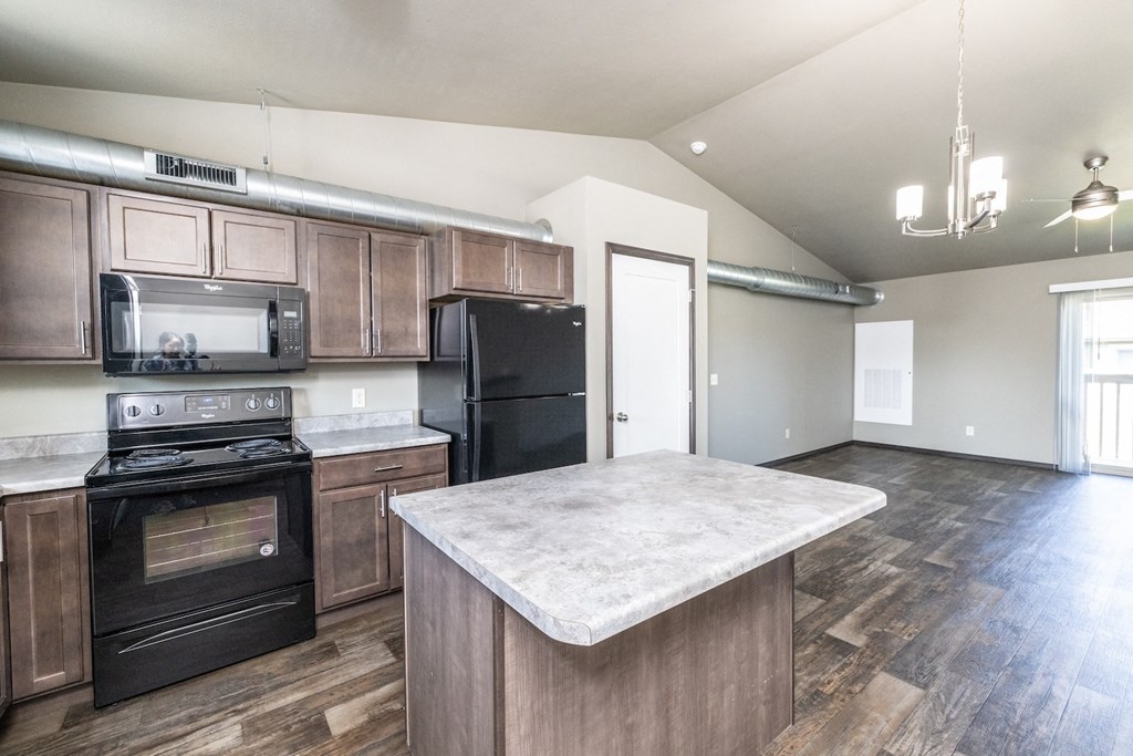 a kitchen with black appliances and a marble counter top