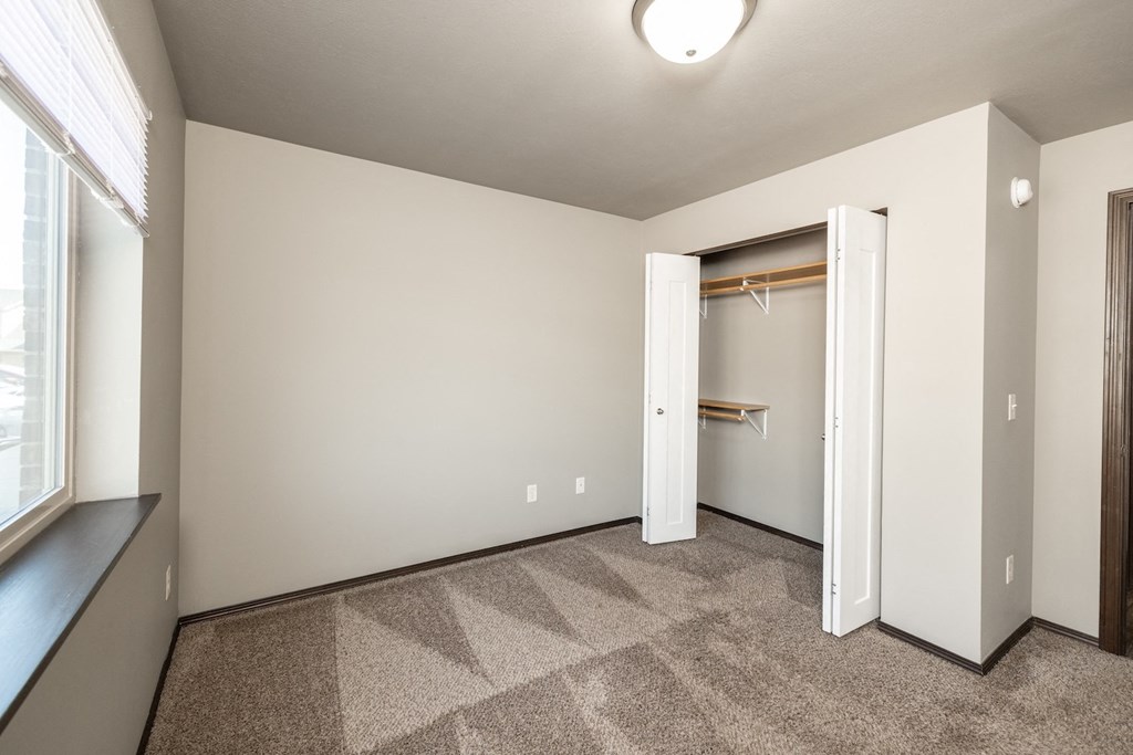 an empty room with a closet and a window