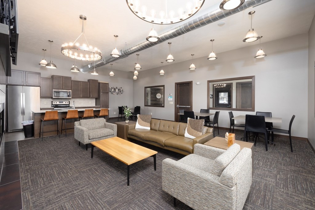 A modern office space with a kitchen area and seating arrangements.