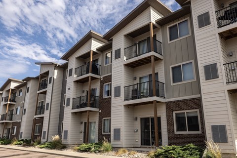 A row of modern apartment buildings with balconies and windows.