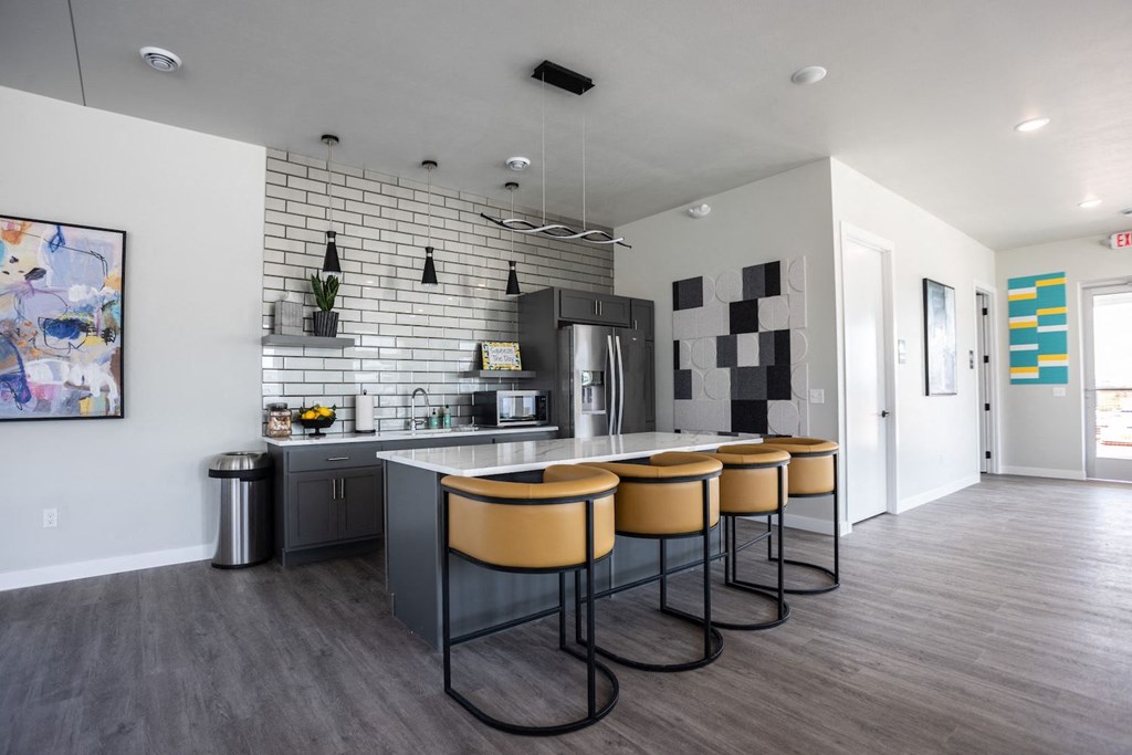 a kitchen with a long island with four chairs