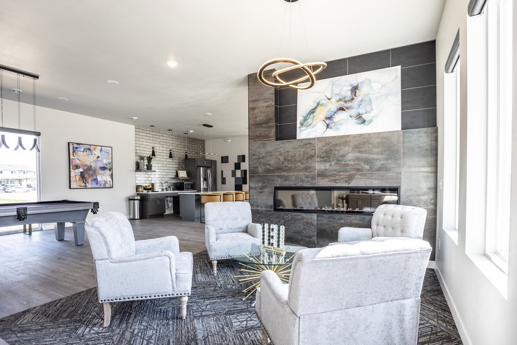 a living room with white chairs and a fireplace