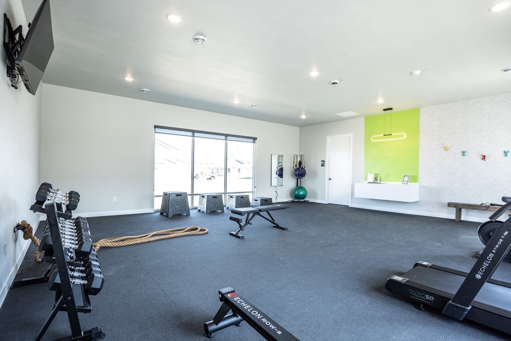 a gym with exercise equipment in a room with a large window