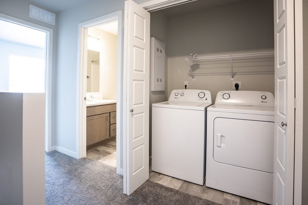 a laundry room with two washers and dryers and a bathroom with a mirror