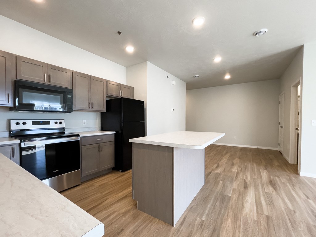 a kitchen with an island and a stove and a refrigerator