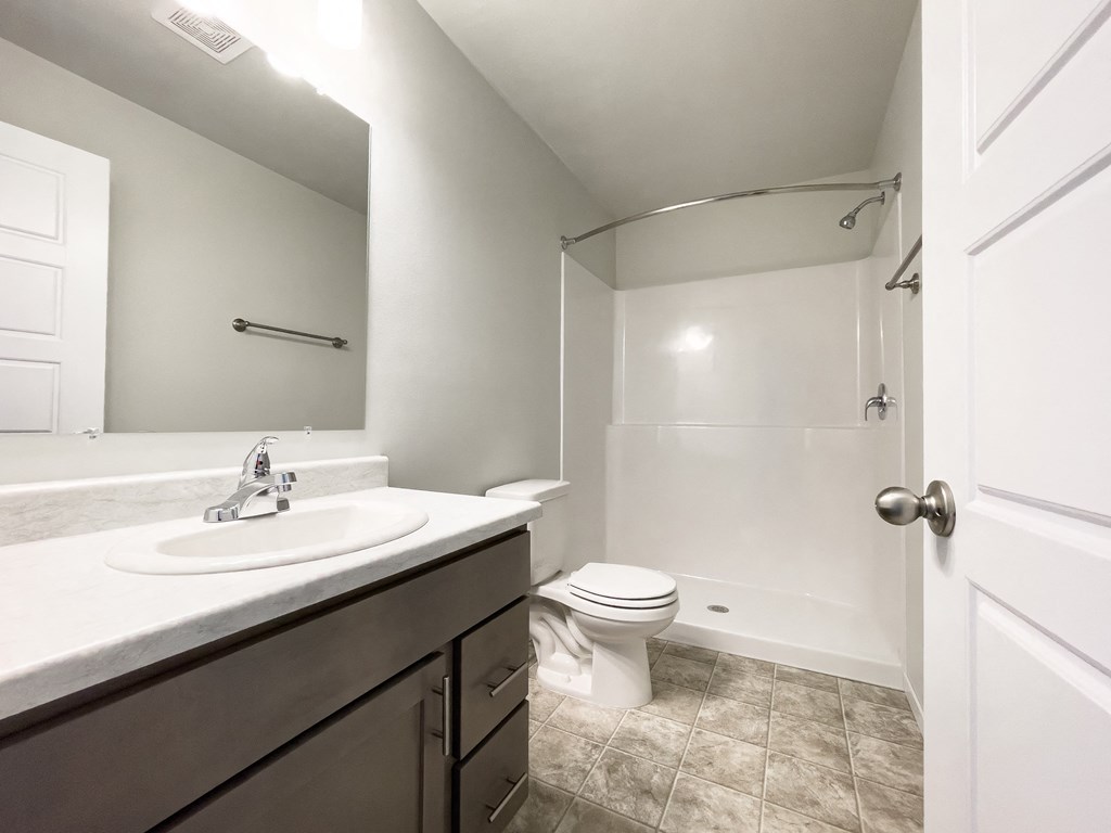 an empty bathroom with a sink toilet and shower