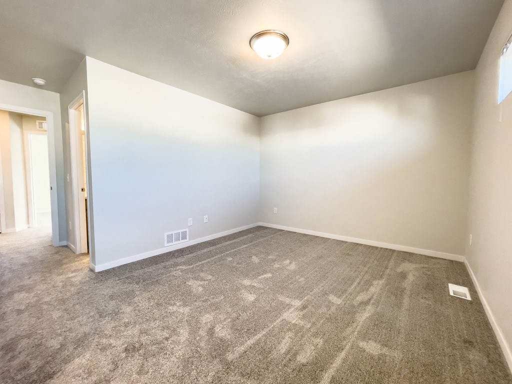 an empty living room with carpet and white walls