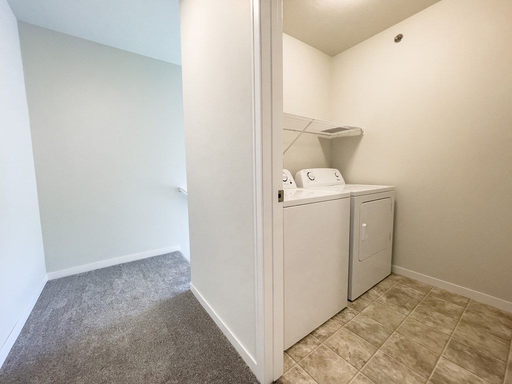 a laundry room with a washer and dryer and a door to the closet