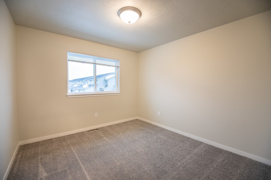 an empty room with carpet and a window