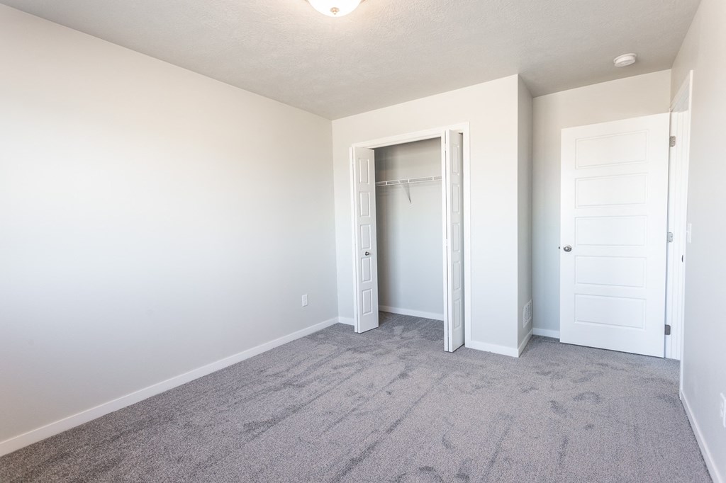 an empty bedroom with white walls and a closet