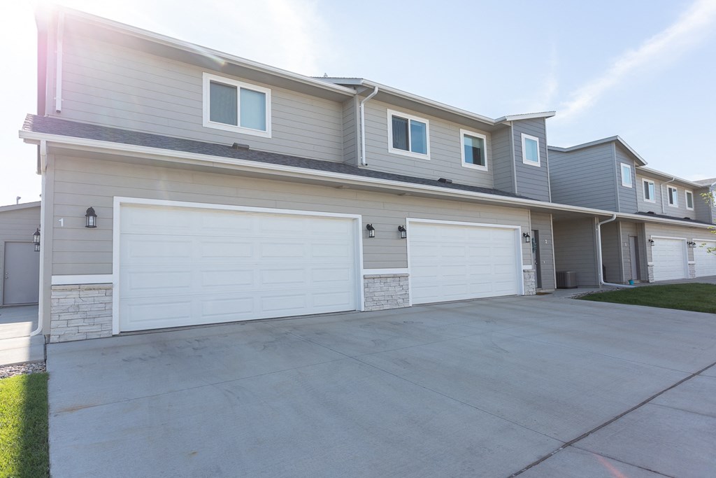 an empty driveway in front of a house with a garage door