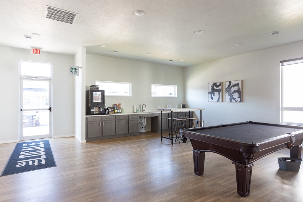 a game room with a pool table and a bar