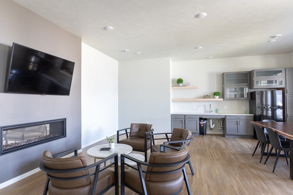 a living room and kitchen with a fireplace and a table and chairs