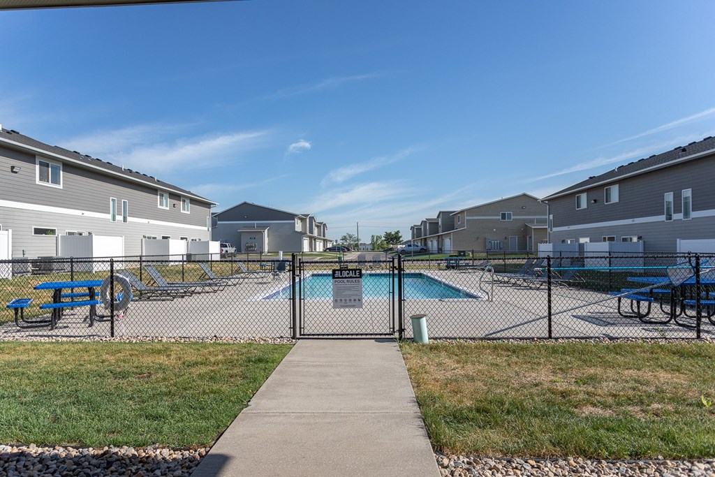 a fenced in swimming pool with a chain link fence in front of some houses