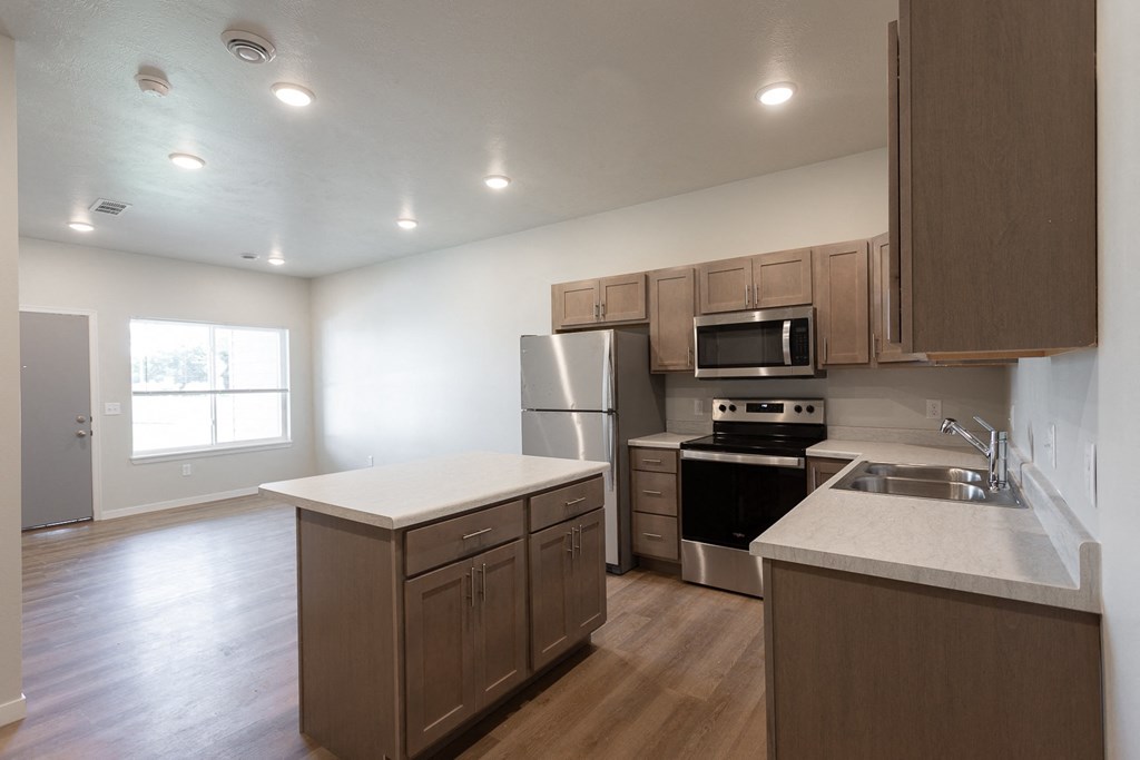 an empty kitchen with wooden cabinets and stainless steel appliances