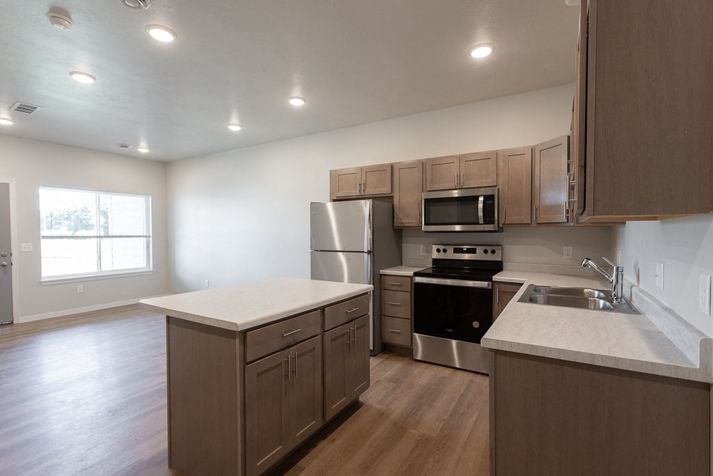 an empty kitchen with wooden cabinets and stainless steel appliances