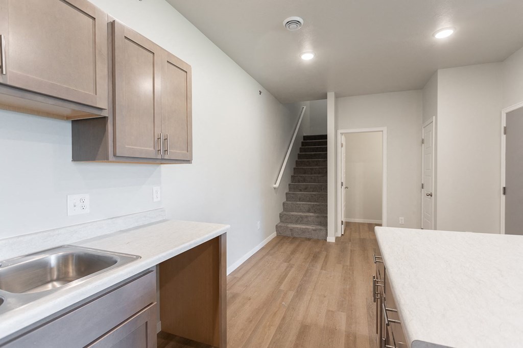 a kitchen with a sink and a counter top and a staircase