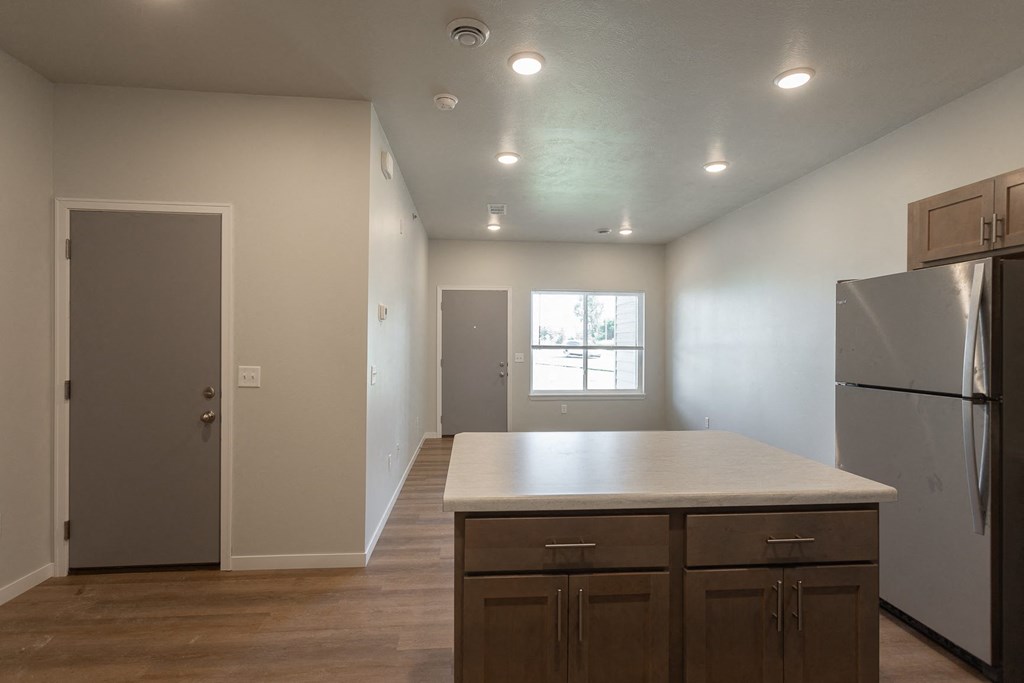 an empty kitchen with a counter top and a refrigerator