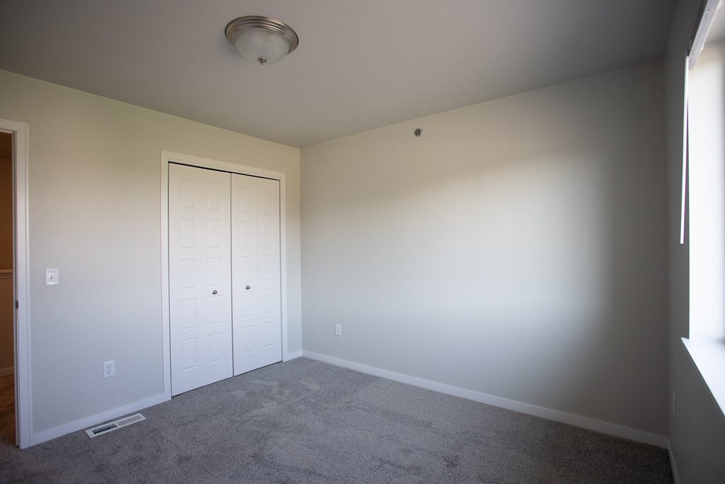 a empty room with a carpeted floor and a closet