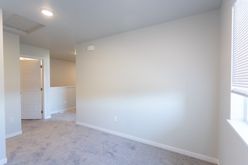 an empty living room with white walls and a white door