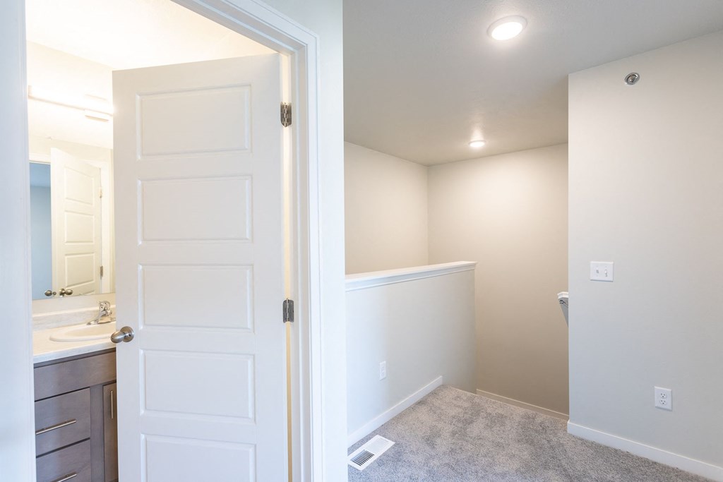 a bathroom with a white door and a sink and a mirror