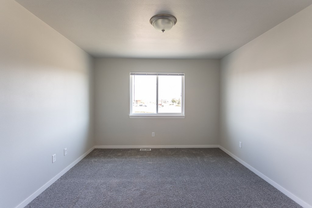 an empty room with carpet and a window