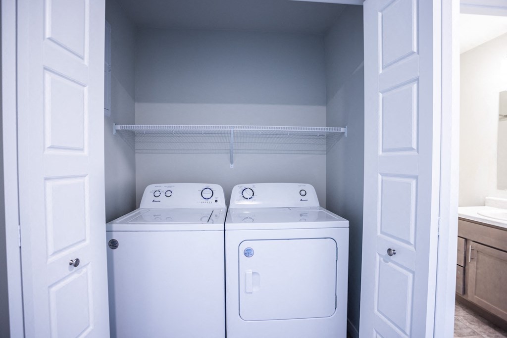 an empty laundry room with two washes and a dryer
