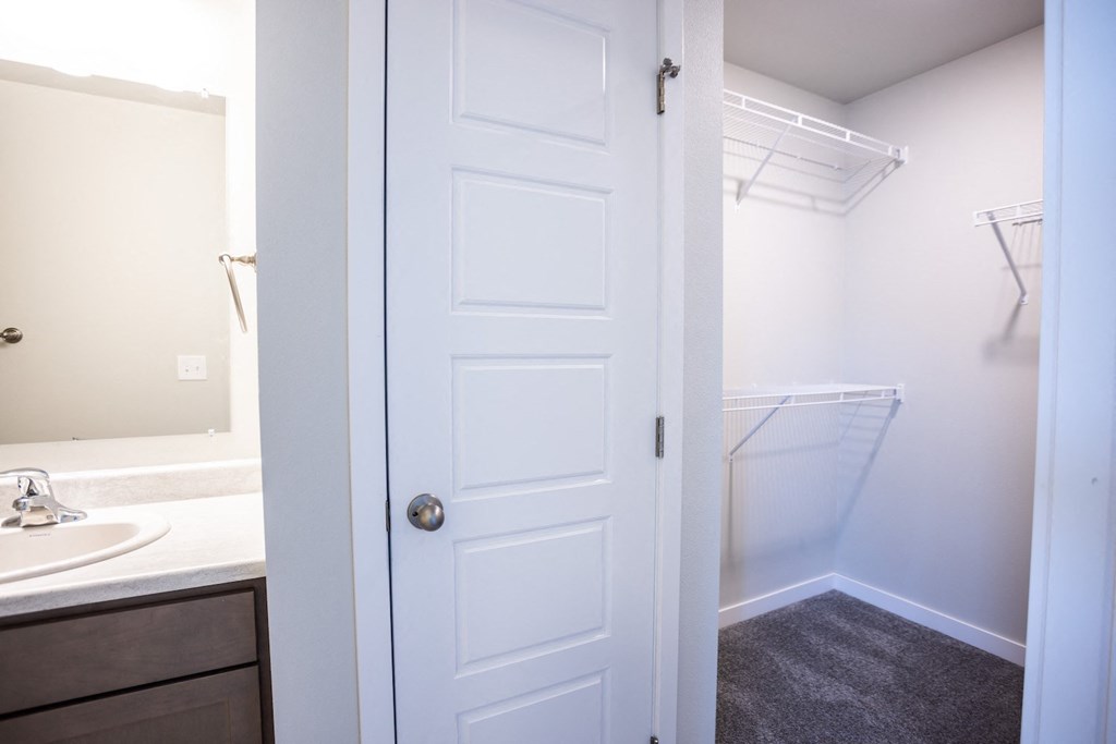 a bathroom with a white door and a shower and a sink