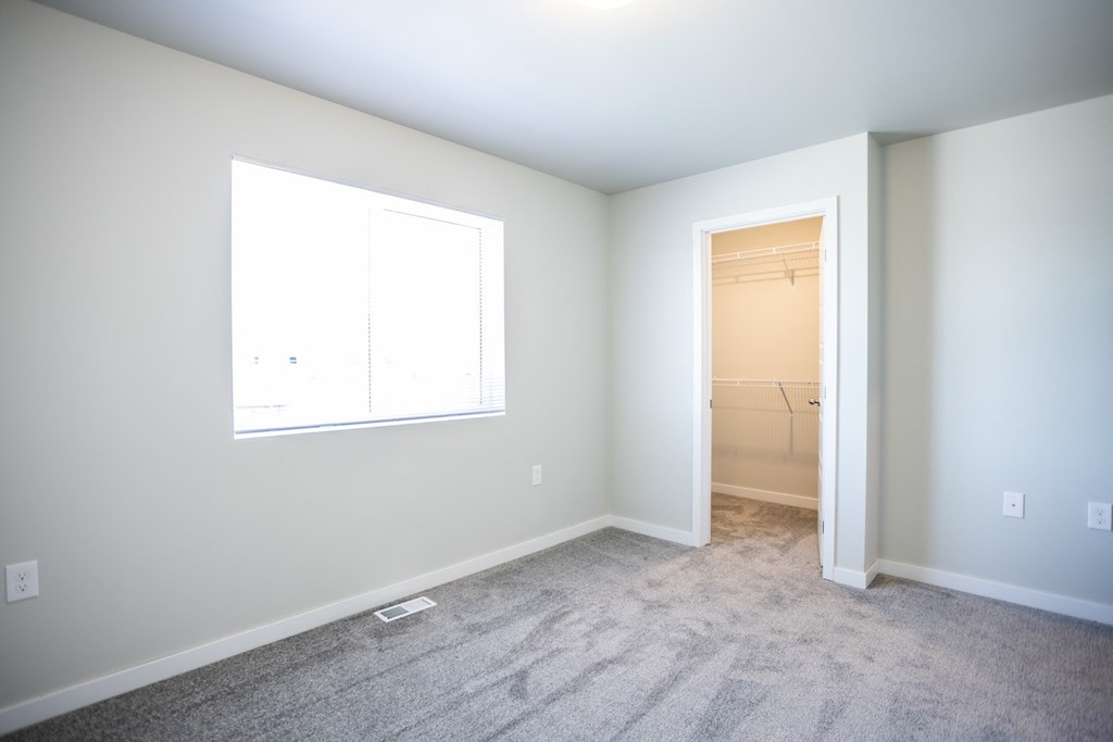 an empty room with a window and a closet