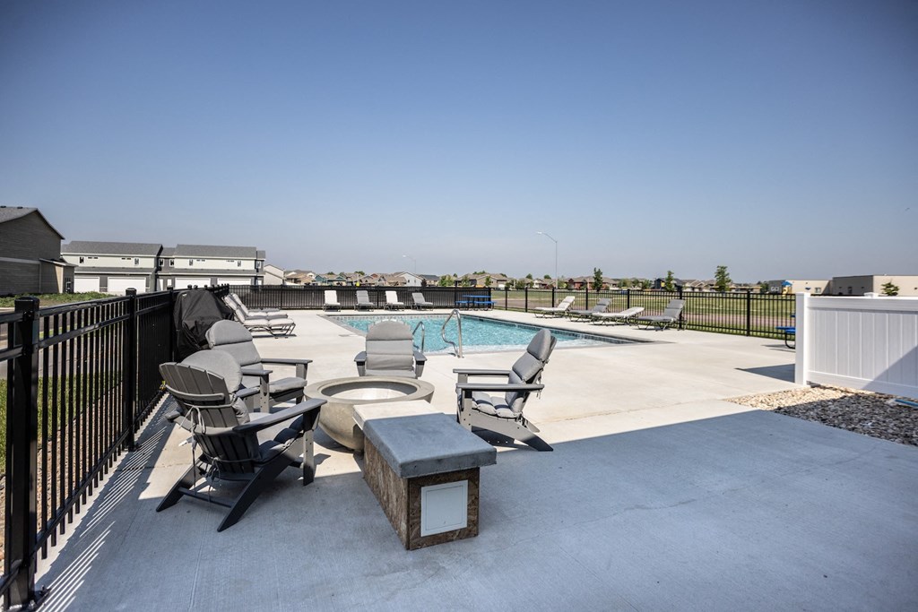 our apartments have a pool and a patio with chairs and tables