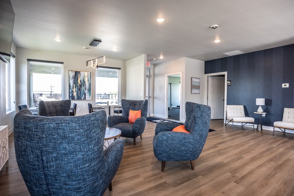 a living room with blue chairs and a wooden floor